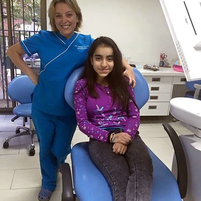 Niña paciente junto a la endodoncista